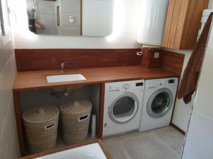 a bathroom with a sink and a washing machine at Maison bord de mer in Marseille