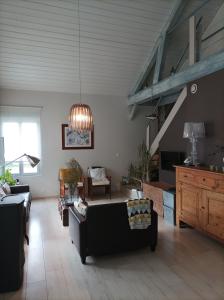 een woonkamer met een bank en een tafel bij La Douc'Heure in Doucier