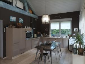 a kitchen with a table and a dining room at La Douc'Heure in Doucier