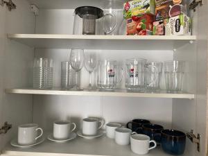 une étagère remplie de verres, de tasses et de tasses dans l'établissement Apartman Valtice, à Valtice