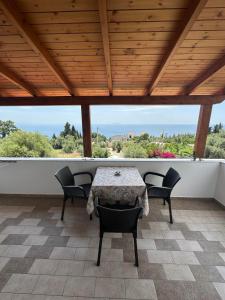 a table and chairs on a patio with a view at XHEKO ROOMS in Dhërmi