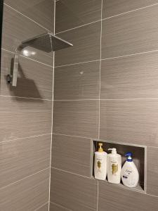 three bottles on a shelf in a bathroom at Charming & Cozy 2BR Cottage in Blacktown