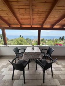 a table and chairs on a patio with a view of the ocean at XHEKO ROOMS in Dhërmi