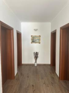a hallway with a vase of flowers in a room at XHEKO ROOMS in Dhërmi