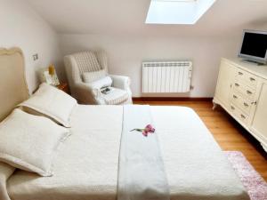 um quarto com uma cama branca e uma cadeira em Holibai, Ledicia, La Perla Del Casco Antiguo, Baiona em Baiona