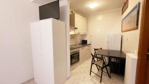 a kitchen with a white refrigerator and a table at CASA EMMA in Chioggia