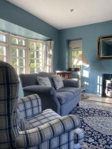 a blue living room with a couch and a chair at The Old Coach House in Redlynch