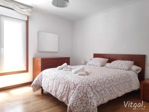 a bedroom with a bed with two stuffed animals on it at Apartamento Naval in Marín