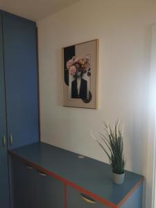 un escritorio con un jarrón de flores en la pared en Apartment Riverside, en Liubliana