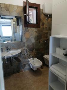 a bathroom with two sinks and a toilet and a mirror at La Finestra su Stintino in Stintino +66 photos