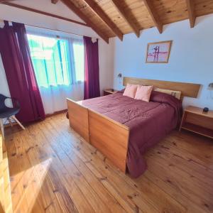 a bedroom with a large bed and a wooden floor at Mirador de las Nieves in San Carlos de Bariloche