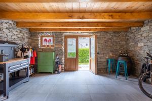 a room with a stone wall and a wooden ceiling at Bed & Bike La Stalla in Masera