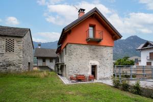 un edificio arancione con balcone sul lato di Bed & Bike La Stalla a Masera