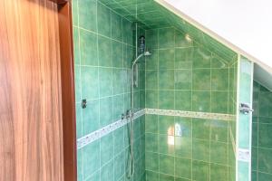baño con ducha con azulejos verdes en Ubytování na výminku en Mikulčice