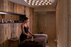 a woman standing next to a bed in a room at Les Regalia Hôtel & Spa in Sainte-Lucie de Porto-Vecchio