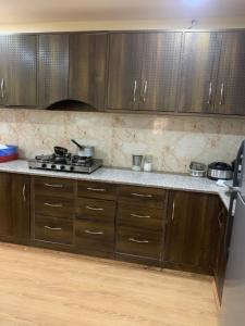 a kitchen with wooden cabinets and a stove top oven at Hinjumaa guest house in Leh +32 photos