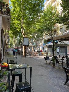 una strada vuota con tavoli, sedie e alberi di Wanda Bed&Breakfast a Napoli