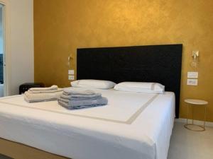 a bedroom with a bed with towels on it at Locanda Carolina Mastino Scala in Sirmione