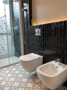 La salle de bains est pourvue d'un lavabo, de toilettes et d'une douche. dans l'établissement Locanda Carolina Mastino Scala, à Sirmione