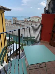 una mesa y sillas en un balcón con vistas al océano en Locanda Carolina Mastino Scala, en Sirmione