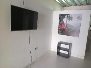 a flat screen tv on a white wall in a room at CASA TORO in Puerto Triunfo