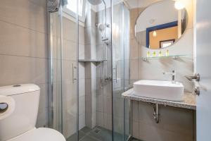 a bathroom with a toilet and a sink and a mirror at Sunset Hotel in Agios Ioannis Kaspaka