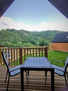 a table and chairs on a deck with a view of a mountain at Panticosa Lodge in Panticosa