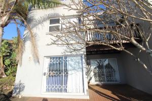 a white house with a door and a balcony at Inn On The Sea 8 in Margate