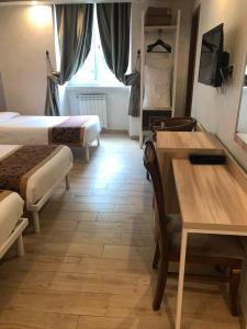 um quarto com 2 camas, uma secretária e uma mesa em Hotel Rome Love- close to Roma Termini em Roma