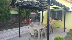 un patio con mesa y sillas bajo una sombrilla en Apartmani Maja 2 en Zrenjanin