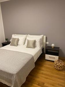 une chambre avec un lit avec des draps blancs et des oreillers dans l'établissement Apartments Marija, à Biograd na Moru