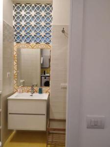 ein Bad mit einem Waschbecken und einem Spiegel in der Unterkunft L & F Apartment's in Minori