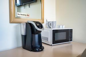 a coffee maker and a microwave on a counter at Beach Club by Beach1 Motel in Wasaga Beach