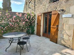 a patio with a table and chairs in front of a building at Domaine de BELLEVUE in Pouançay