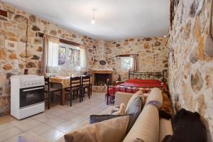 een woonkamer met een bank en een keuken met een tafel bij Lithahiro stone house in Kerion
