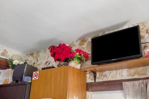een flatscreen-tv die bovenop een muur staat bij Lithahiro stone house in Kerion