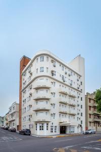 a white apartment building on a city street at Hotel Dom Rafael Executivo in Santa Maria