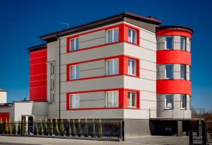 a red and white building with a black fence at Camelot in Sandomierz