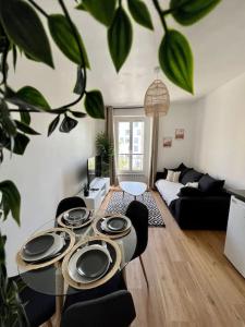 Bel appartement Porte d’Italie في لو كرملين-بيستر: غرفة معيشة مع طاولة عليها لوحات