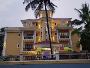 a large yellow building with umbrellas in front of it at Anthy’s à la Campagne in Benaulim