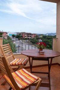 een tafel en stoelen op een balkon met uitzicht op de stad bij Casa Olbiamare by Wonderful Italy in Olbia