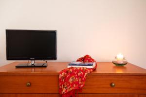 a television sitting on top of a dresser with a candle at Casa Olbiamare by Wonderful Italy in Olbia