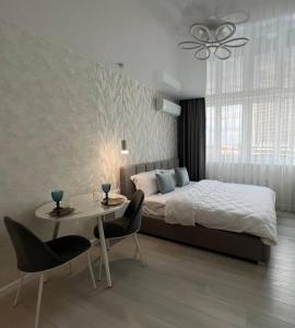 um quarto com uma cama, uma mesa e cadeiras em Deluxe apartments - Viva Ukraine em Kiev