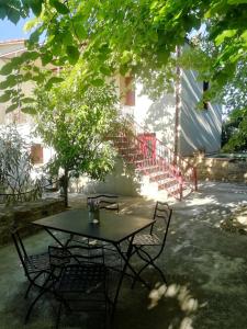 a table and chairs sitting under a tree in a yard at Sirianis flat in Chios