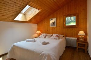a bedroom with a large white bed with a skylight at Résidence Joséphine in Châtel