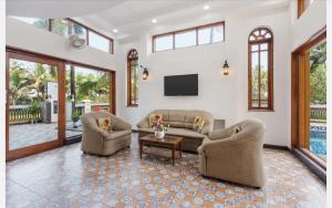 a living room with two couches and a tv at Anthy’s à la Campagne in Benaulim