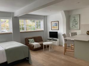 a bedroom with a bed and a couch and a table at Yew Tree House in Woodstock