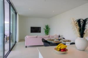 ein Wohnzimmer mit einem rosa Sofa und einem Tisch in der Unterkunft Modern west facing 2-bedroom apartment in Higueron West in Fuengirola