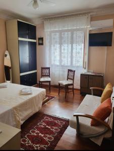 1 Schlafzimmer mit einem Bett, 2 Stühlen und einem Fenster in der Unterkunft Maison Manni' B&B in Soverato Marina