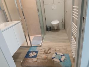 a small bathroom with a toilet and a rug at Koksijde Penthouse in Koksijde +10 photos